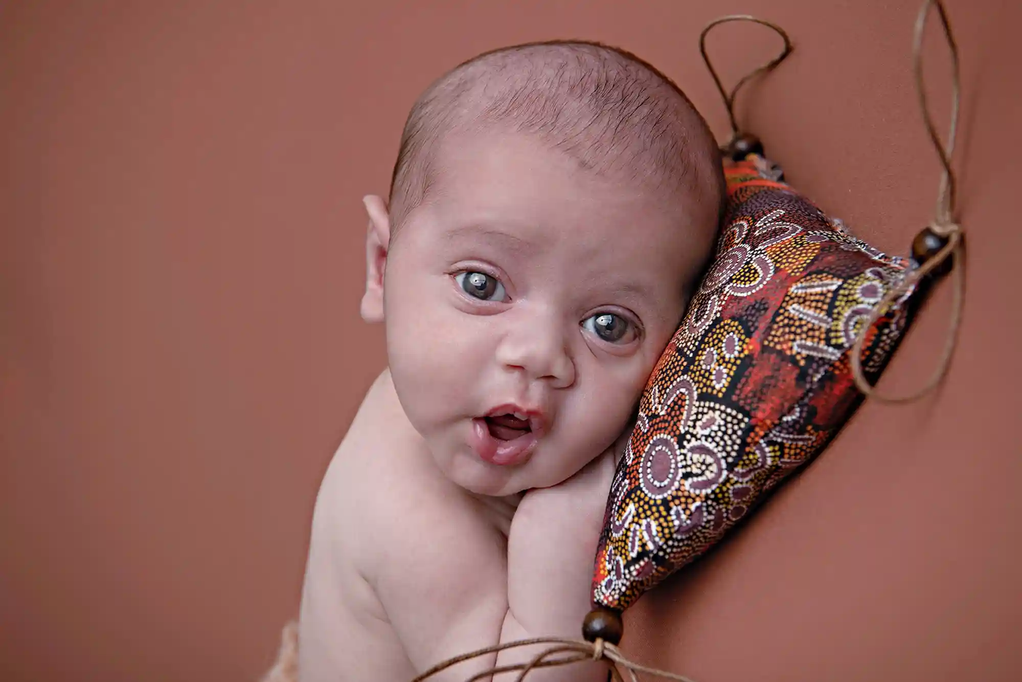 Newborn baby cradled gently at Sky Portraits Studio, Sydney - newborn photography